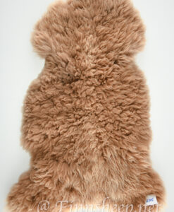 A brown sheepskin rug on top of white background.