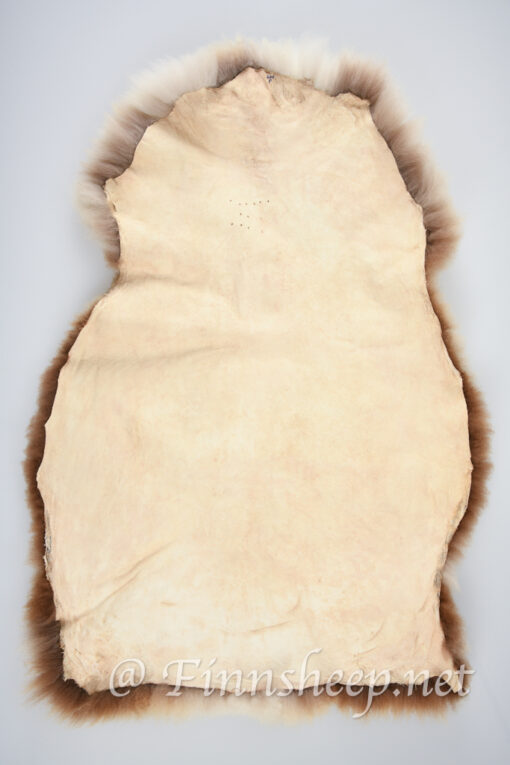 A white and brown fur rug on top of a floor.